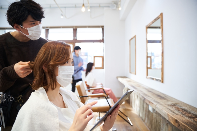 サロンで女性のヘアカットをする美容師