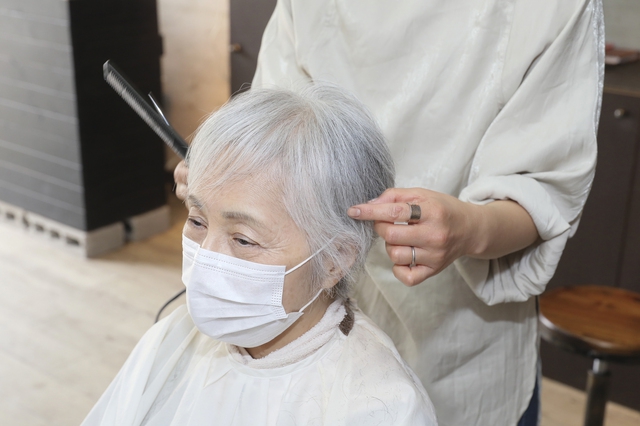 ヘアセットを受ける白髪女性