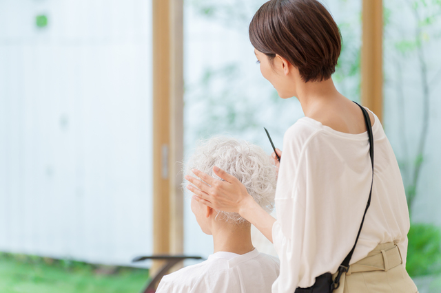 訪問美容師と女性の後ろ姿