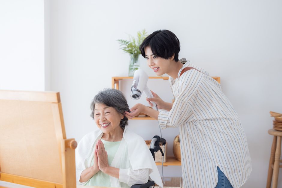 シニア女性の髪を乾かす女性美容師